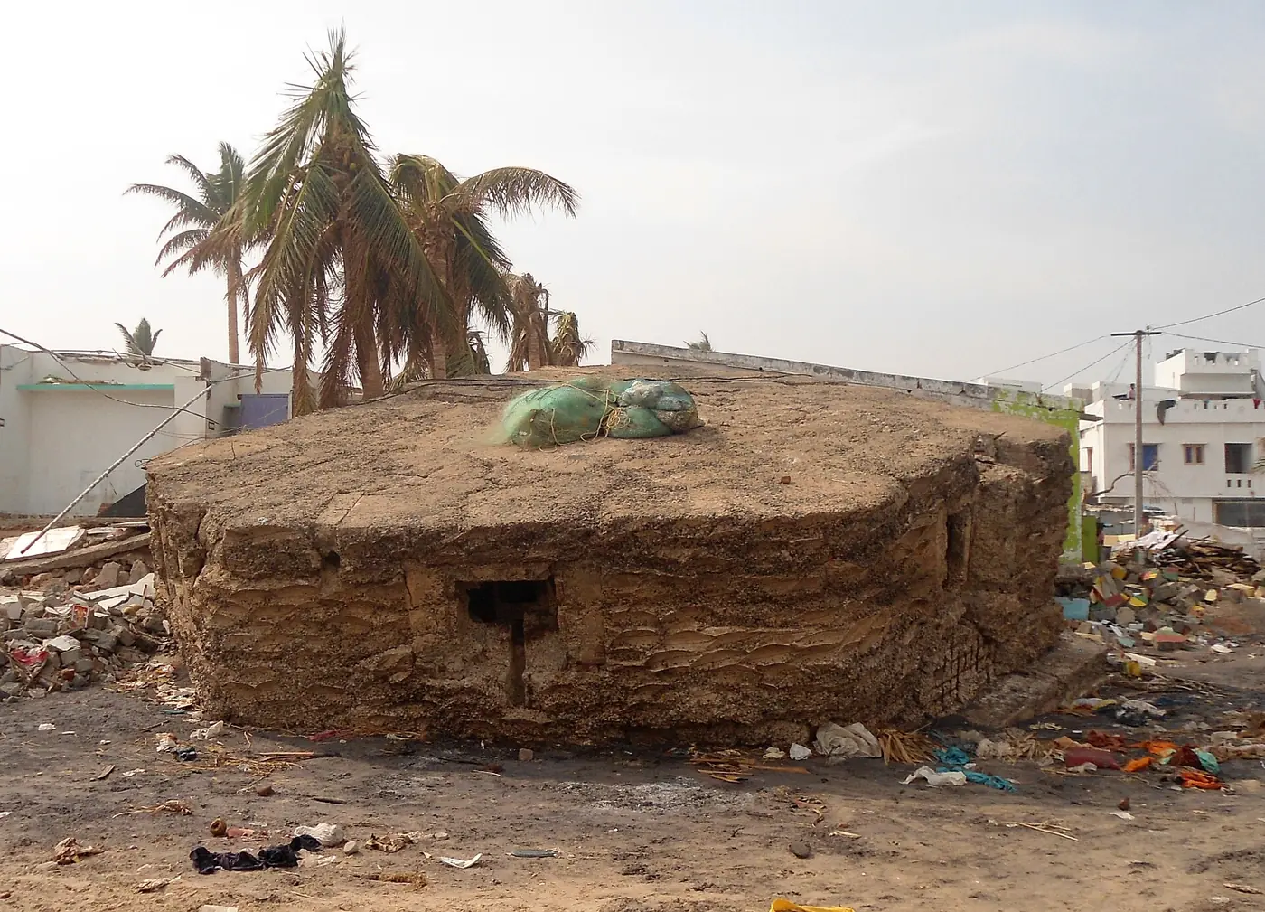 Photograph of an old Second World War concrete bunker lying broken on the beach at Visakhapatnam after Cyclone Hudhud