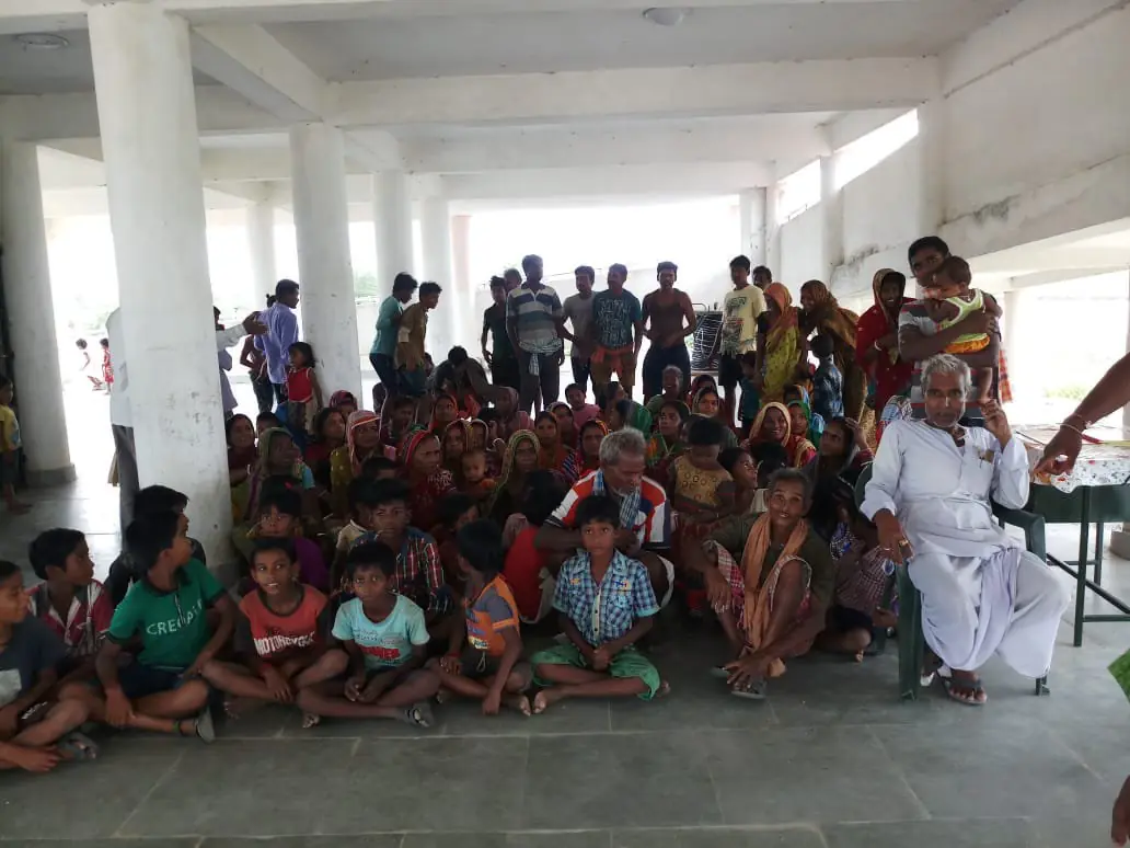 Photograph of evacuated families sitting together on the floor of a cyclone shelter in Bhadrak district, Odisha