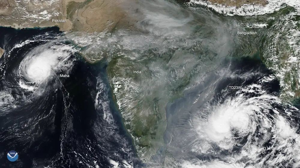 Satellite image from 5 November 2019 showing Cyclone Maha over the Arabian Sea on the left and the developing storm that became Bulbul over the Bay of Bengal on the right, with smog over north India